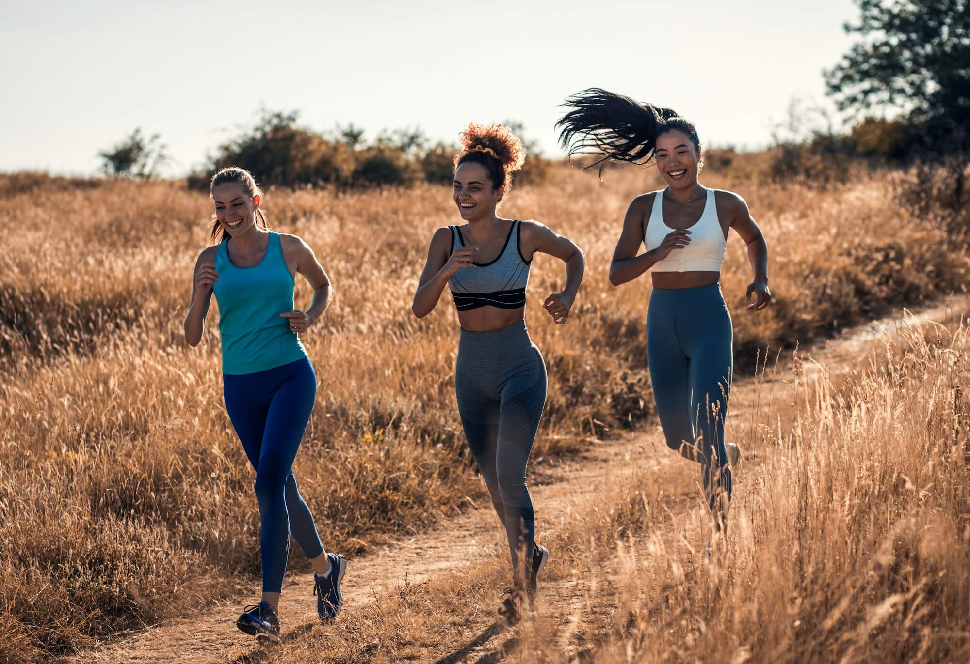 Group of sporty female friends running outdoors.